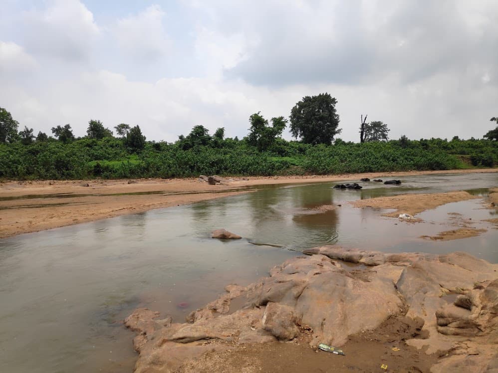 Scenic river with rocky banks and forested countryside near Itkhori